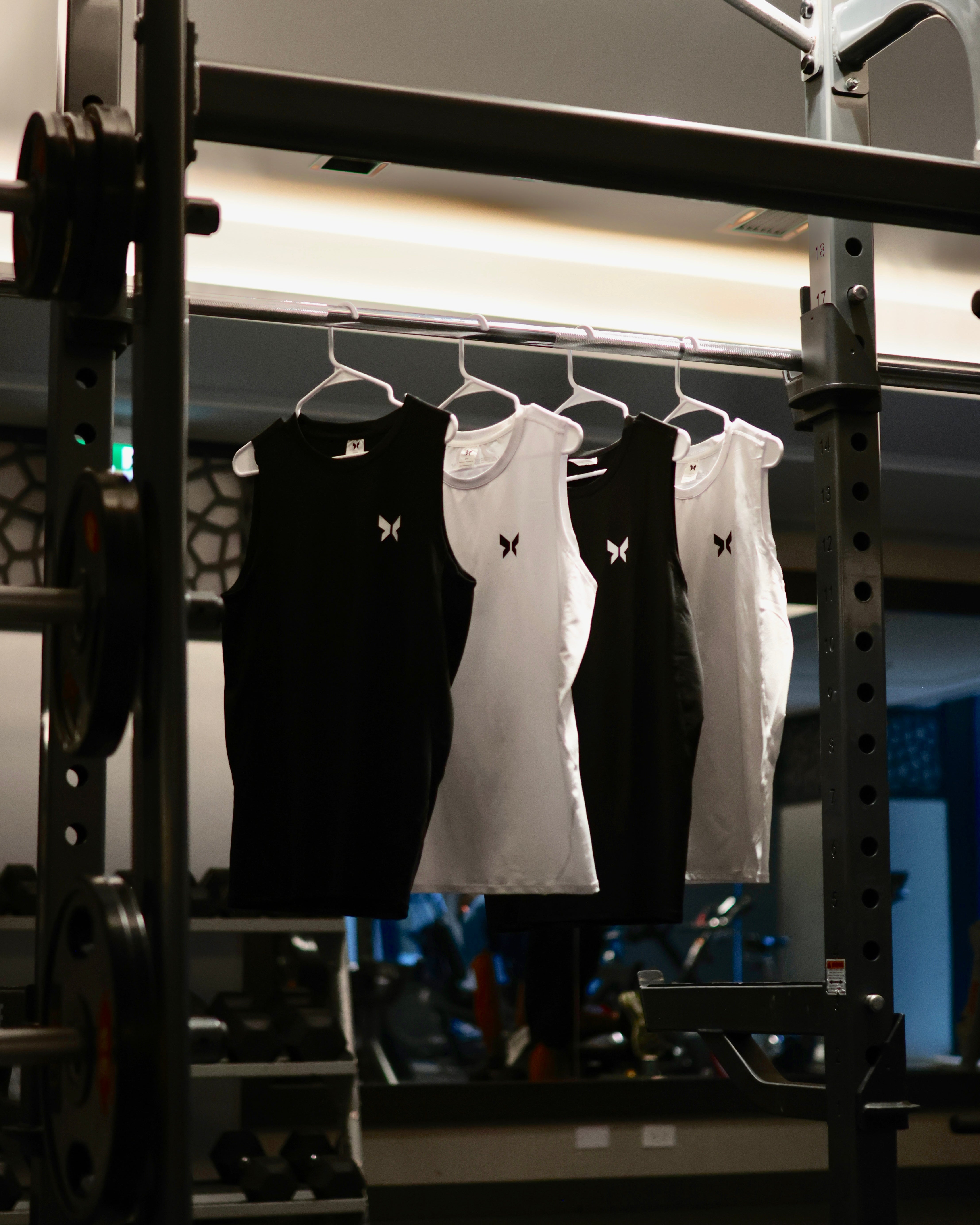 Shapeshift black and white gym tank tops for men, minimalist muscle-fit workout shirts made with premium breathable fabric. Sleek performance activewear designed for gym training, bodybuilding, and fitness style. Shapeshift gym wear brand focuses on comfort, detail, and confidence through minimalist athletic design.